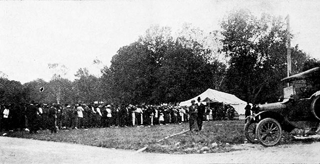 Long line of people waiting outside a voting tent.