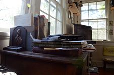 Shot showing metal bookend with portrait and stacked books Margret Magnus books, God in the Word.