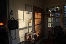 Shot of the study’s back wall and empty large bulletin board shadowed with the pattern from the window panes.